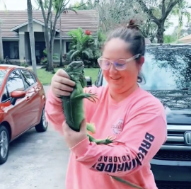 woman holding iguana